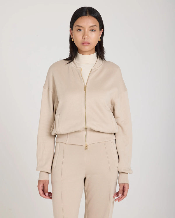 Woman wearing Mello Lyocell Fleece Zip-Through Jacket in Beige, showcasing luxurious craftsmanship and refined design.