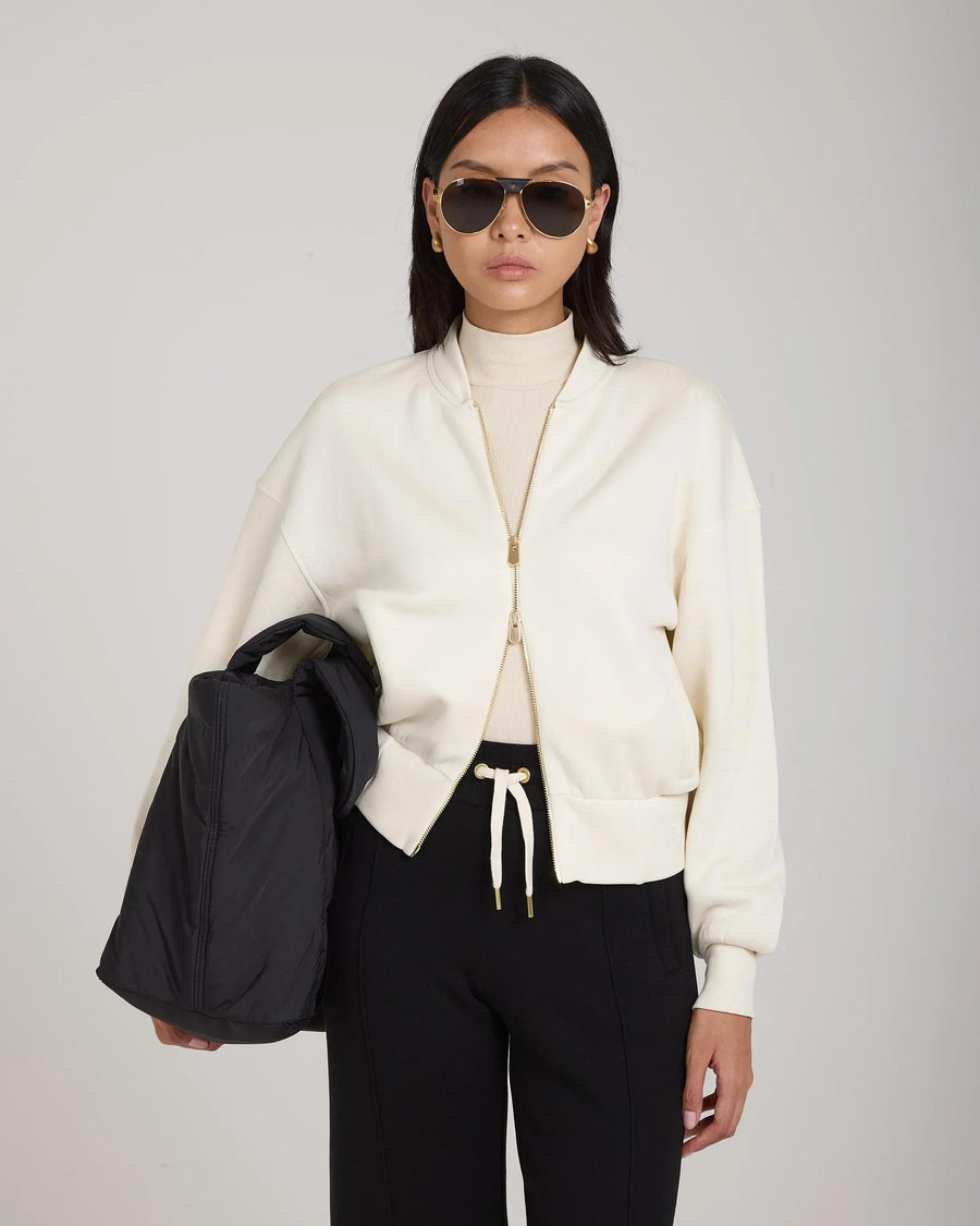 Model wearing Emello Zip Through Jacket in buttery-soft cream lyocell, showcasing gold hardware and a relaxed fit.