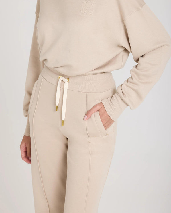 Mello Lyocell Fleece Wide Leg Pants in Beige with gold accents, showcasing relaxed fit and elegant tactile finish.