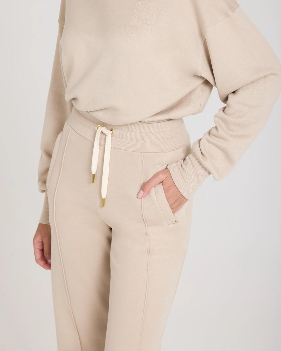 Mello Lyocell Fleece Wide Leg Pants in Beige with gold accents, showcasing relaxed fit and elegant tactile finish.