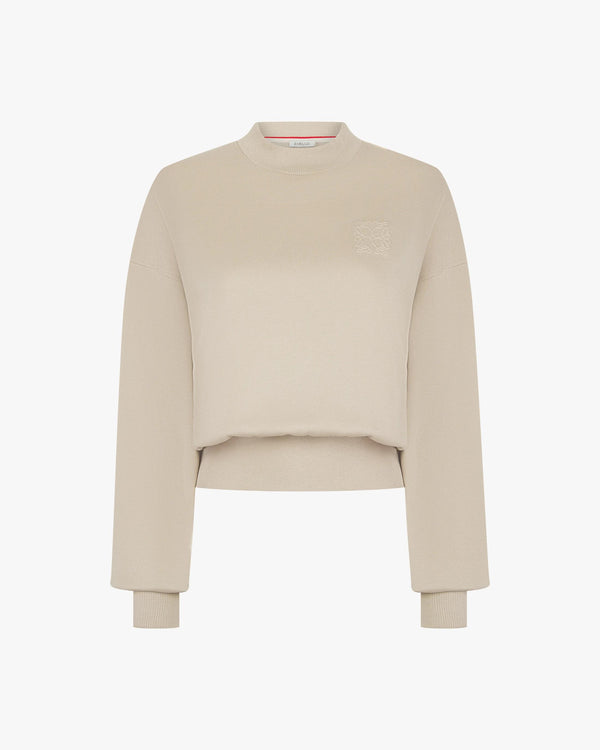 Beige lyocell sweatshirt with debossing on the chest, featuring ribbed cuffs and crew neck.