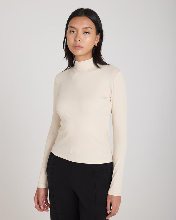 Emello Forma Ribbed Lyocell-Cotton Blend Turtleneck Top in Beige worn by model