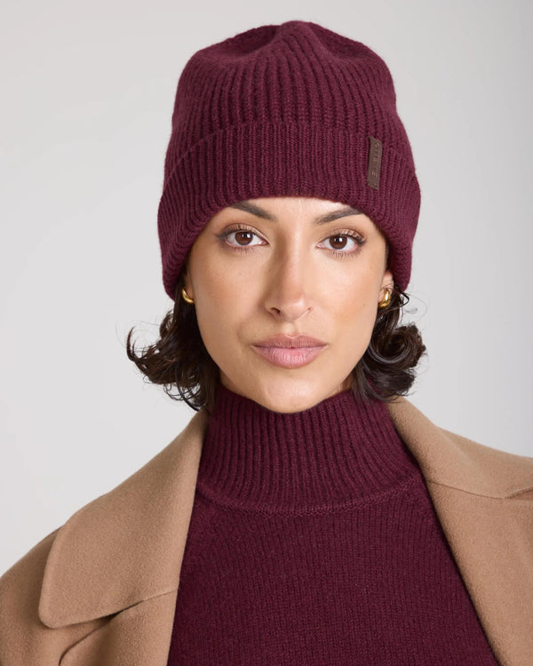 Burgundy merino cashmere beanie with fold-over cuff worn by a model.