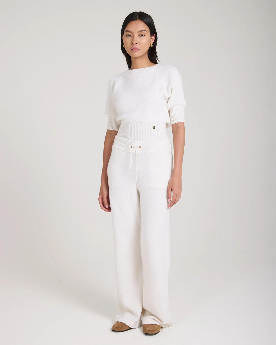 Model wearing Emello Wide Leg Trouser in Cream Merino Wool Cashmere with gold hardware and pockets, front view.