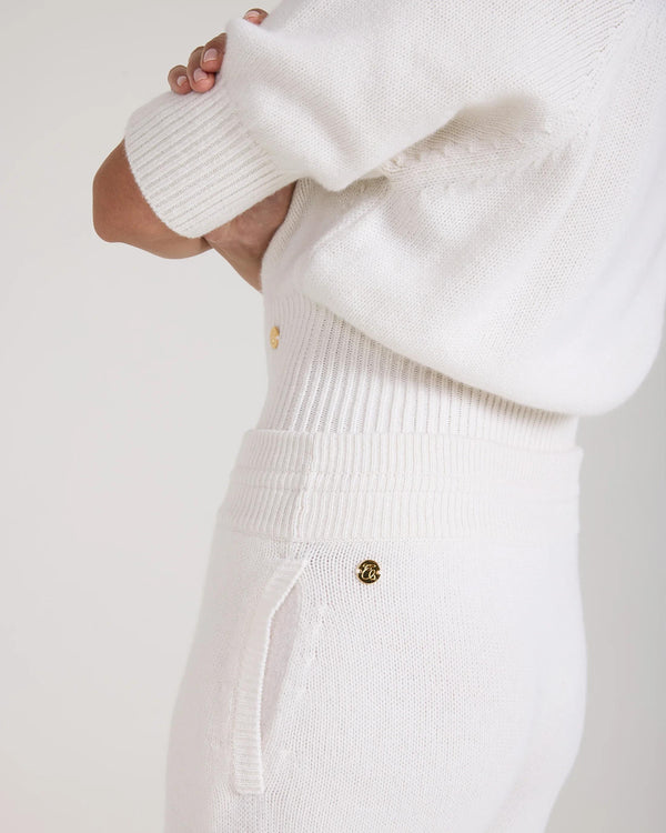 Detail shot of Emello's wide leg trouser in cream, showcasing gold hardware, merino wool and cashmere blend.