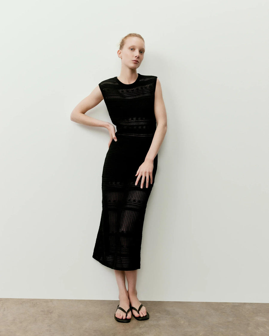 Model wearing Emello's black panelled open knit midi dress, showcasing its structured yet breathable silhouette.