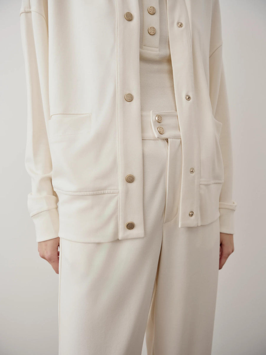 Elegant cream modal popper jacket featuring collarless design, relaxed shoulders, and a soft, cupro-like finish.