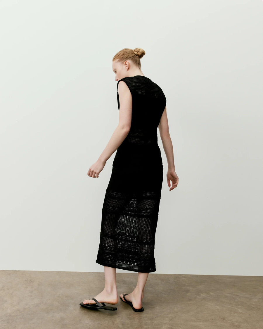 Panelled Open Knit Midi Dress in black, featuring a sleeveless design with alternating opaque and openwork sections, worn with flat sandals.