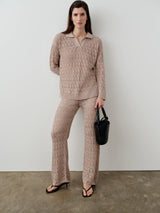 An elegant woman dressed in a neutral open-knit polo top and matching pants, showcasing Emello's refined luxury womenswear.