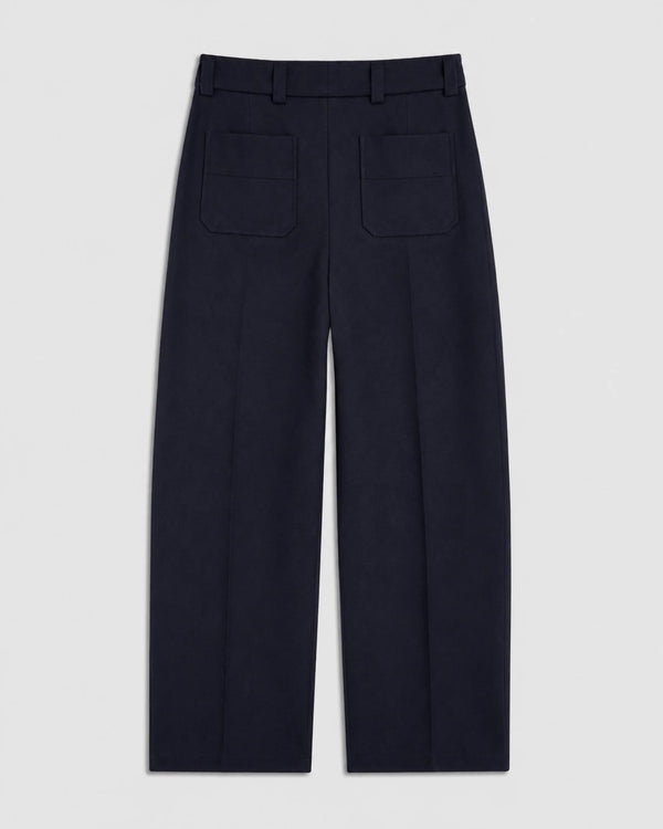 Back view of Emello Pleated Wool Trousers in navy, illustrating the expert tailoring and soft drape of the fabric.