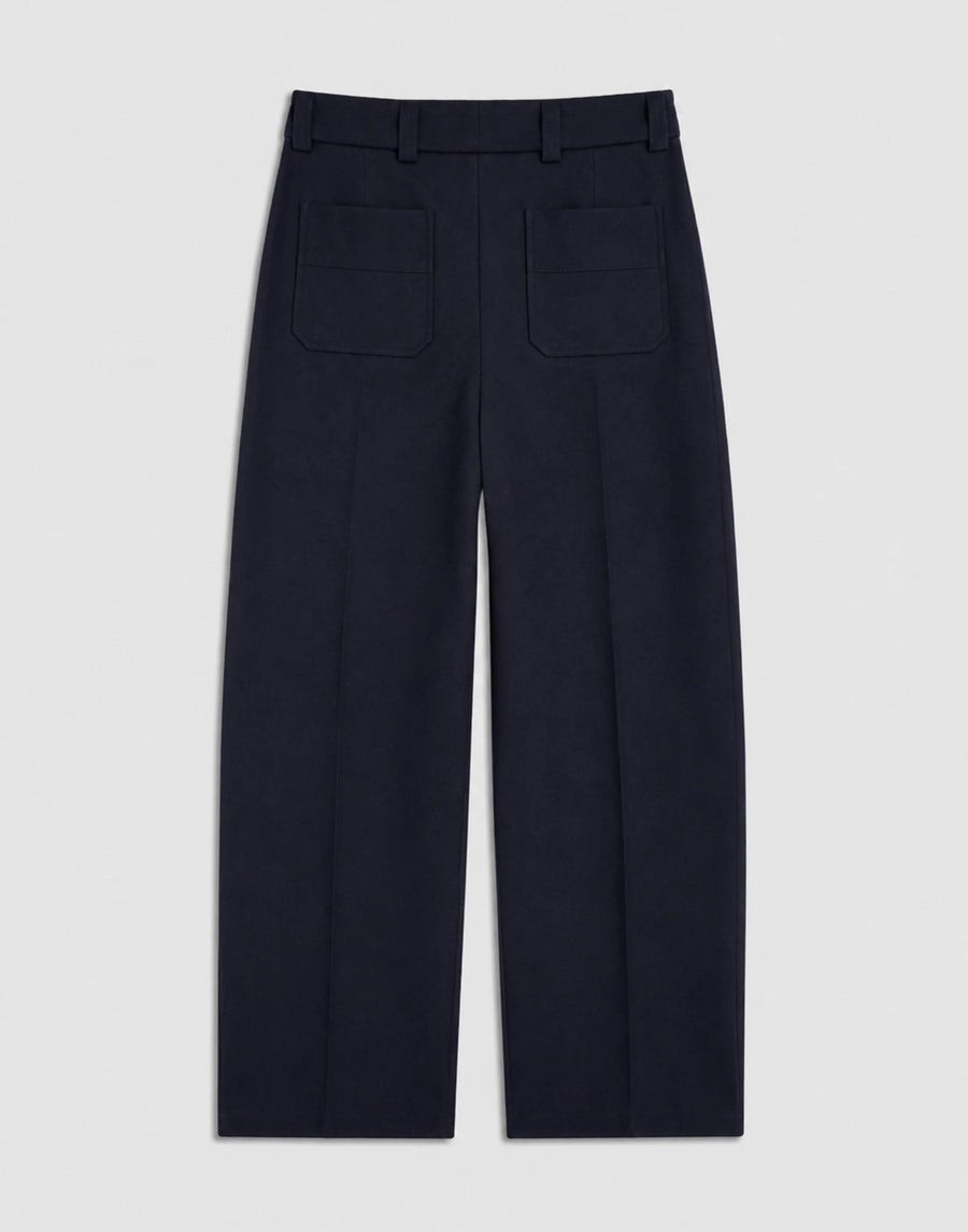 Back view of Emello Pleated Wool Trousers in navy, illustrating the expert tailoring and soft drape of the fabric.