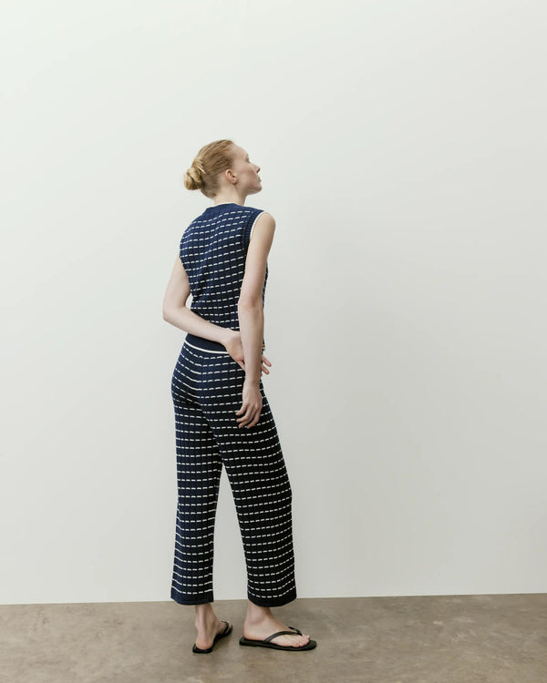 Model wearing Emello Pointelle Knit Cropped Trousers in navy with a cream grid pattern, styled effortlessly with a matching vest.