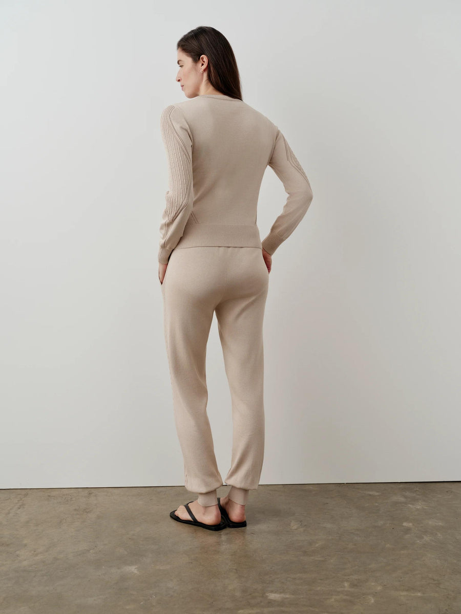 Model wearing Emello's neutral silk blend pointelle trousers, showcasing the vertical detailing and fluid drape.