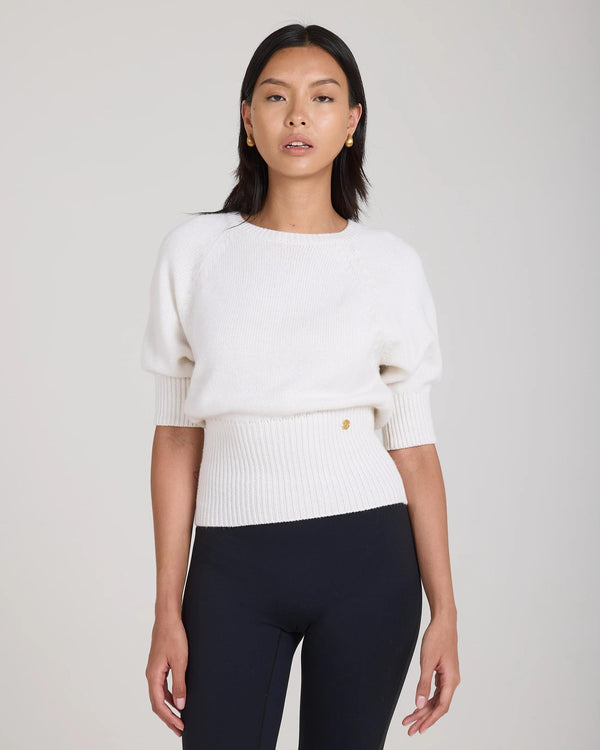 Cream puff sleeve sweater in merino wool cashmere with gold hardware, modeled with confidence.
