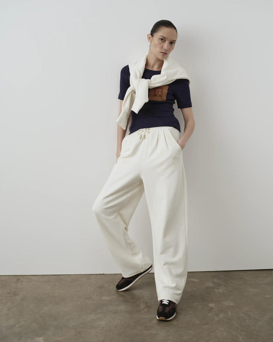 Model wearing Emello Relaxed Straight Leg Trousers in cream against a neutral background.