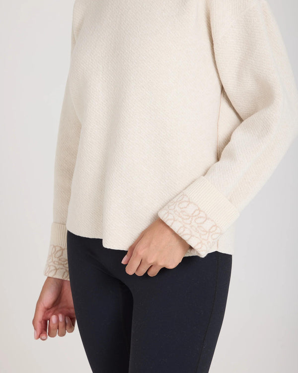Elegant cream reversible jacquard cashmere sweater by Emello, showcasing tactile elegance and refined design.