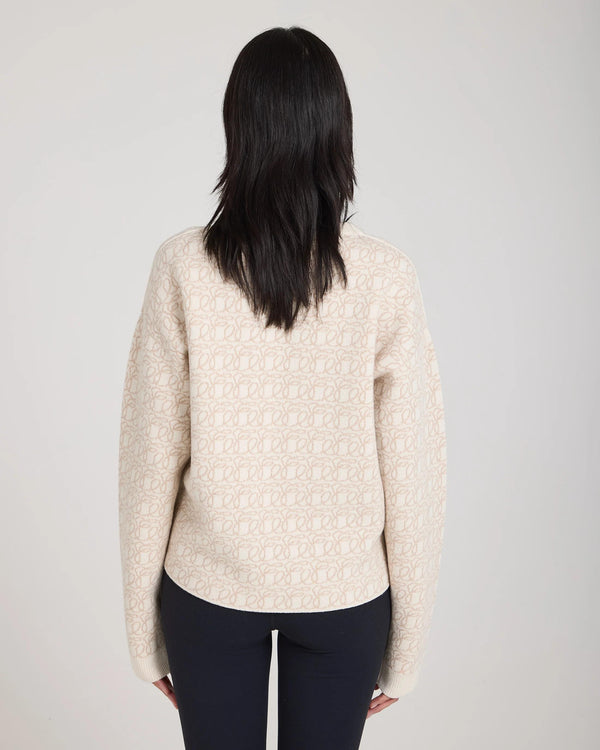 Back view of luxurious cream reversible jacquard cashmere sweater worn elegantly.