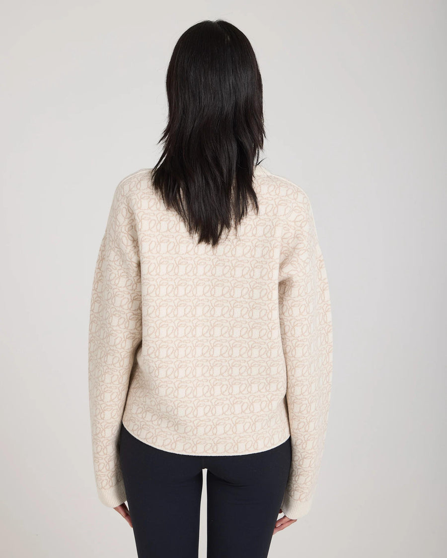 Back view of luxurious cream reversible jacquard cashmere sweater worn elegantly.