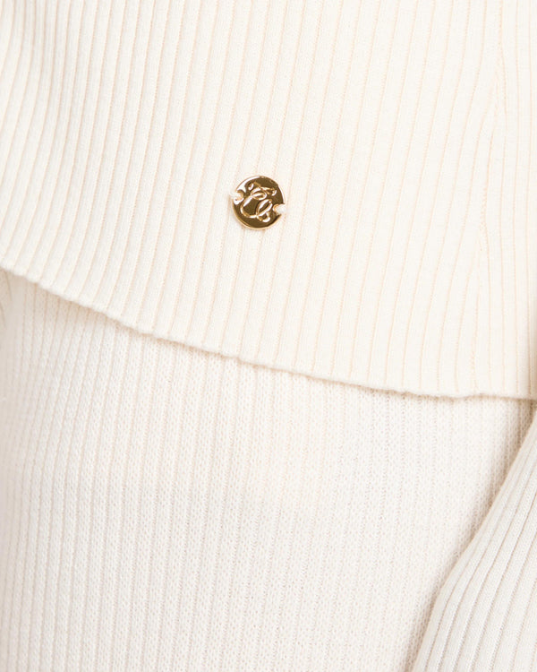 Close-up of the Sorella Ribbed Zip Through Cardigan in Cannoli Cream showing gold-finish embellishments and ribbed texture.
