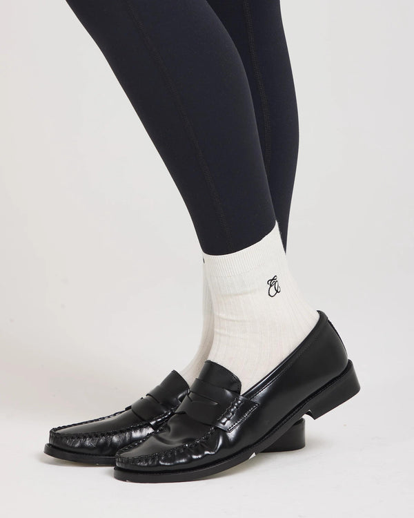 Emello Ribbed Cotton Half-Crew Socks in Cream with Embroidery, styled with black loafers and leggings.