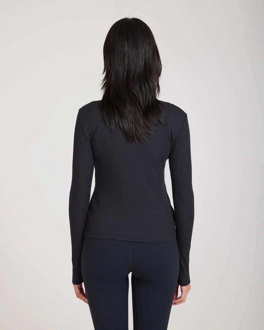 Back view of Emello Forma Ribbed Lyocell-Cotton Blend Turtleneck Top in black, showcasing slim fit and ribbed texture.