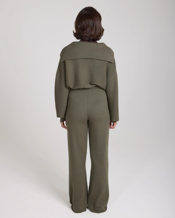 Back view of model wearing Emello Sorella Ribbed Half Zip Jumper in Olive.