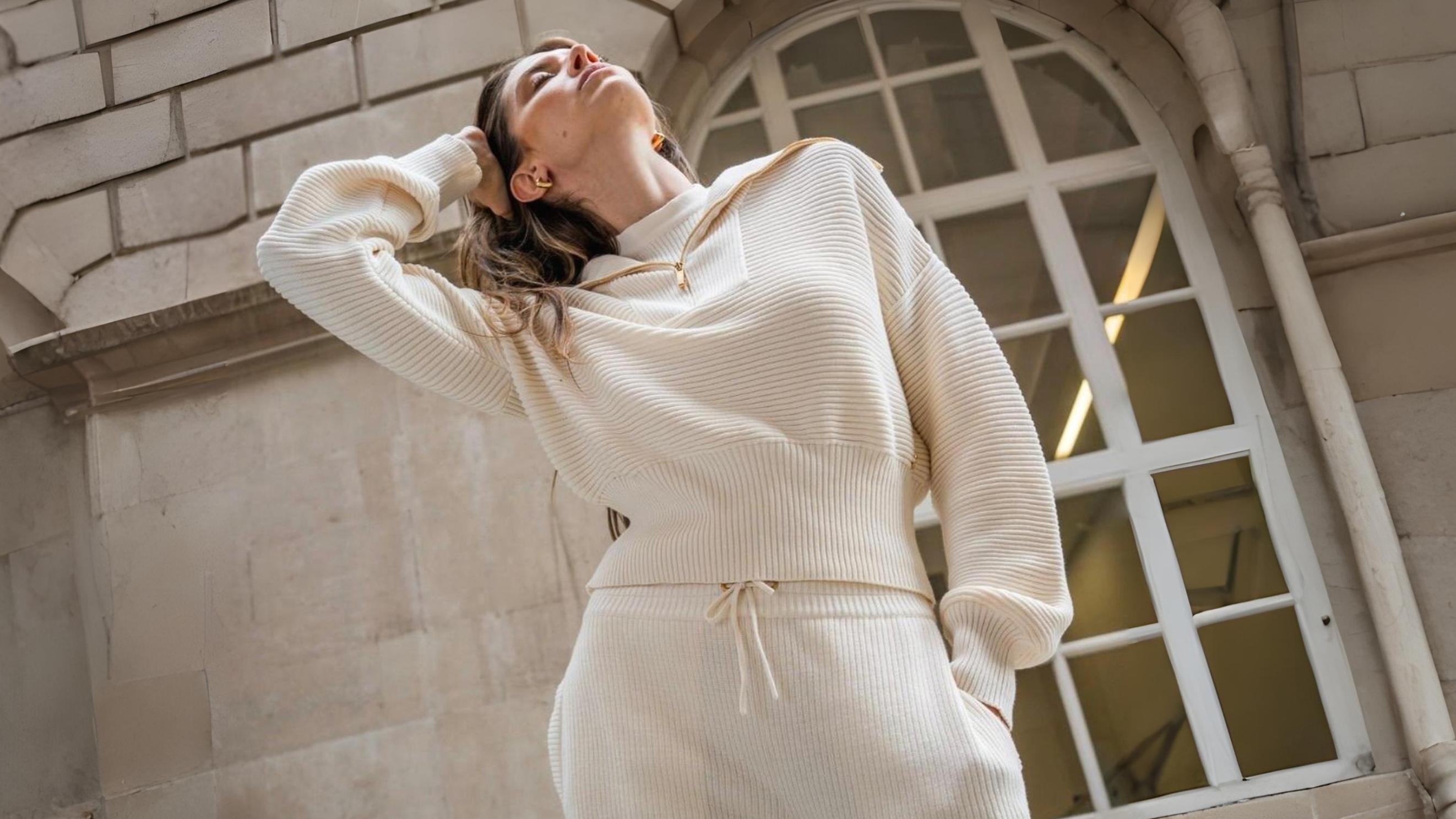 Woman wearing ivory ribbed knit loungewear set in an architectural city setting