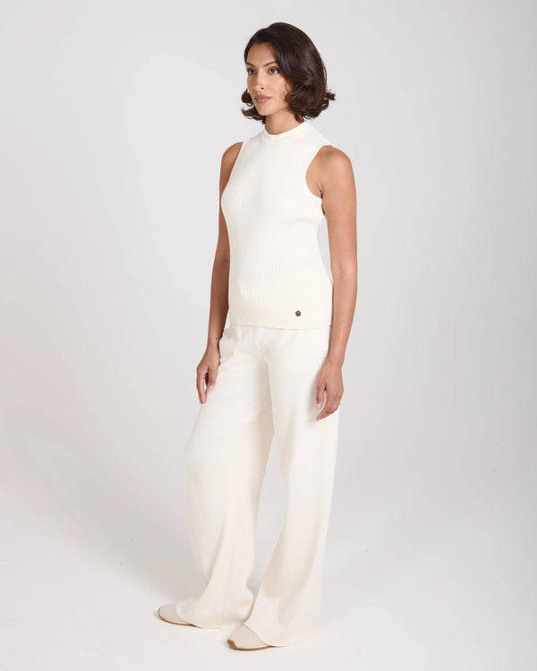 Model wearing Emello Sorella Ribbed Knit Vest in Cream, showcasing its slim fit and refined structure.