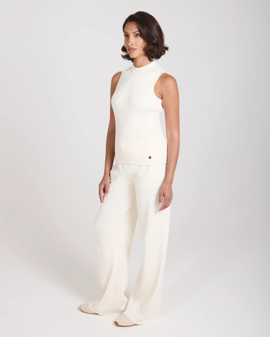 Model wearing Emello Sorella Ribbed Knit Vest in Cream, showcasing its slim fit and refined structure.