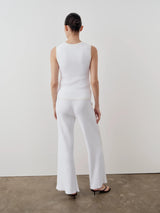 Model wearing Emello's tonal ribbed knit trousers in bright cream.