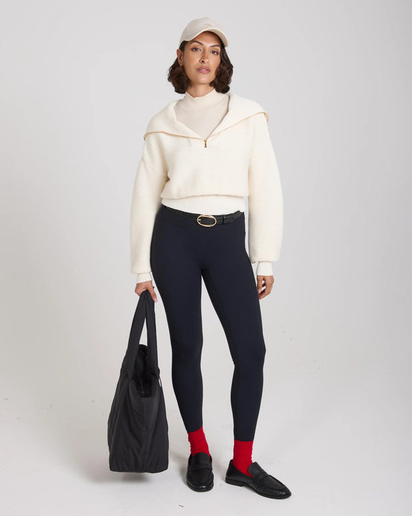 Model wearing red ribbed cotton half-crew socks with embroidered disc