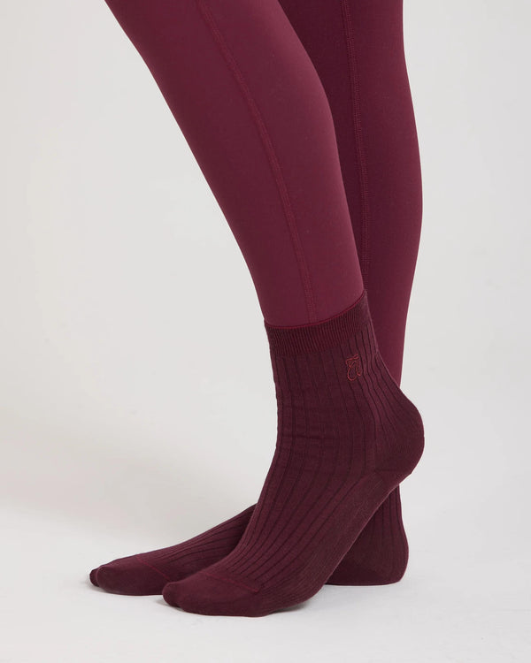 Burgundy ribbed half-crew socks with embroidered logo by Emello, photographed in soft light.