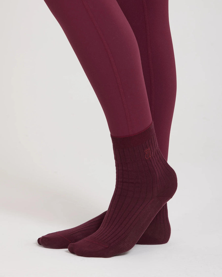 Burgundy ribbed half-crew socks with embroidered logo by Emello, photographed in soft light.