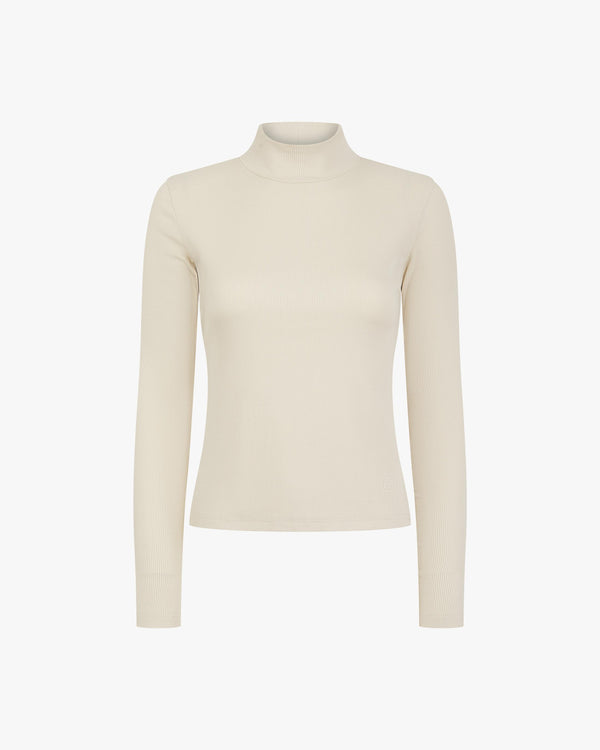 Elegant beige ribbed turtleneck in lyocell-cotton from Emello, showcasing tactile refinement and luxurious comfort.