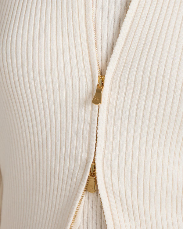Close-up of Sorella Ribbed Zip Through Cardigan in cream with gold zip detailing.