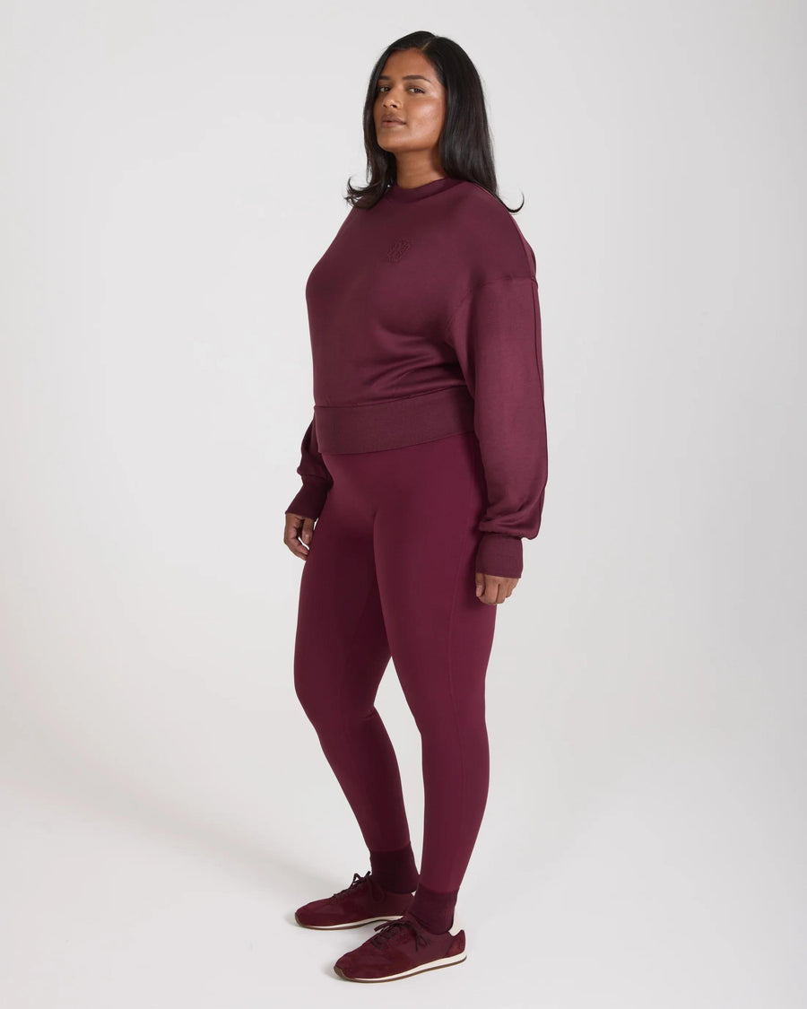 Model wearing Emello purple leggings with belt loops, showcasing a sculpting fit and high waist.
