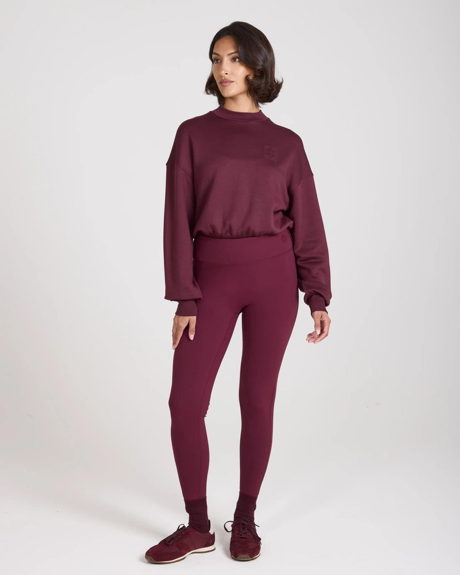 Model wearing Emello purple leggings with belt loops, showcasing a sculpting fit and high-waisted design.