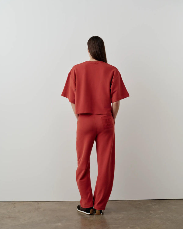 Back view of Emello's Short Sleeve Pocket Sweatshirt in red, showcasing its relaxed boxy silhouette and tonal embroidery.