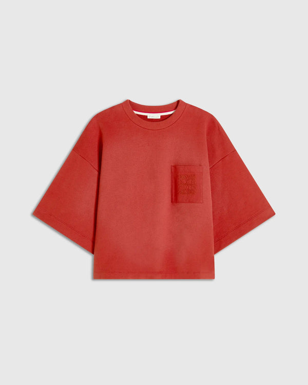 Red short sleeve sweatshirt with chest pocket and tonal embroidery, showcasing a relaxed, boxy silhouette.