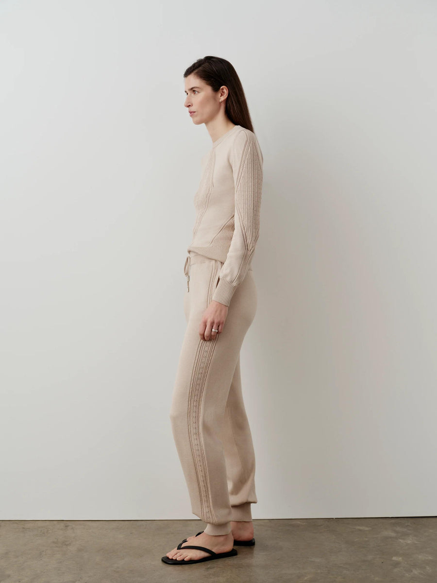 Model wearing Emello Silk Blend Pointelle Trousers in a neutral setting, showcasing the fluid drape and elegant pointelle pattern.
