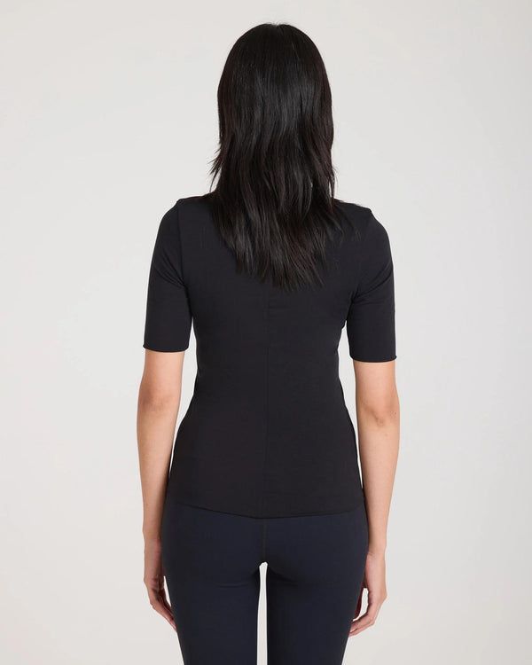 Back view of a black silky lyocell jersey double-layer top highlighting the central seam and slim fit.