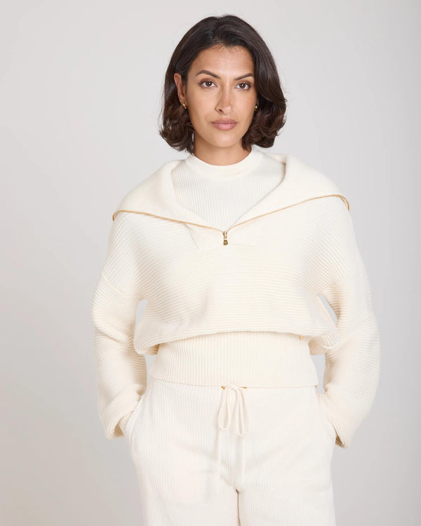 Sorella Ribbed Half Zip Jumper in cream with gold finish zip, worn by model with relaxed fit in soft daylight.