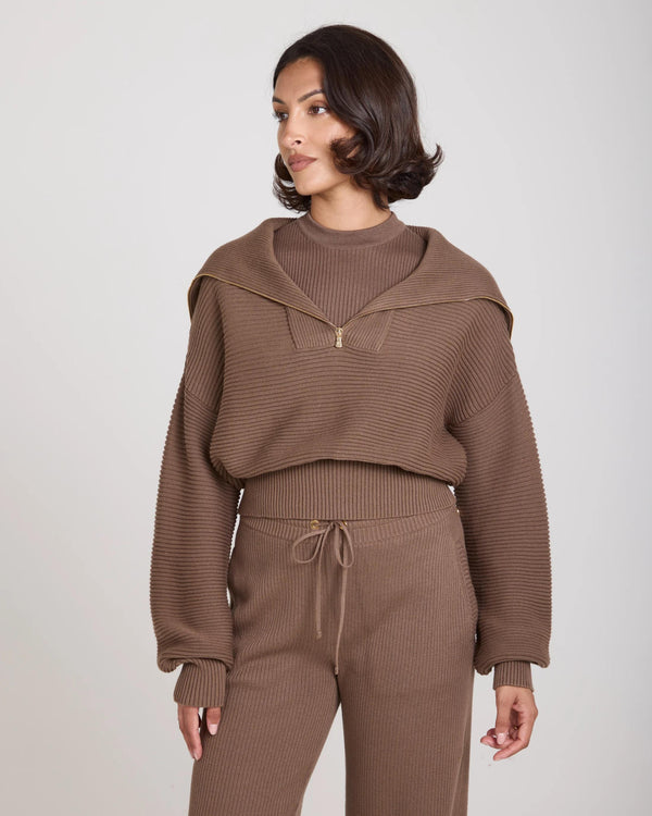 Model wearing taupe Sorella Ribbed Half Zip Jumper with relaxed silhouette and gold accents.