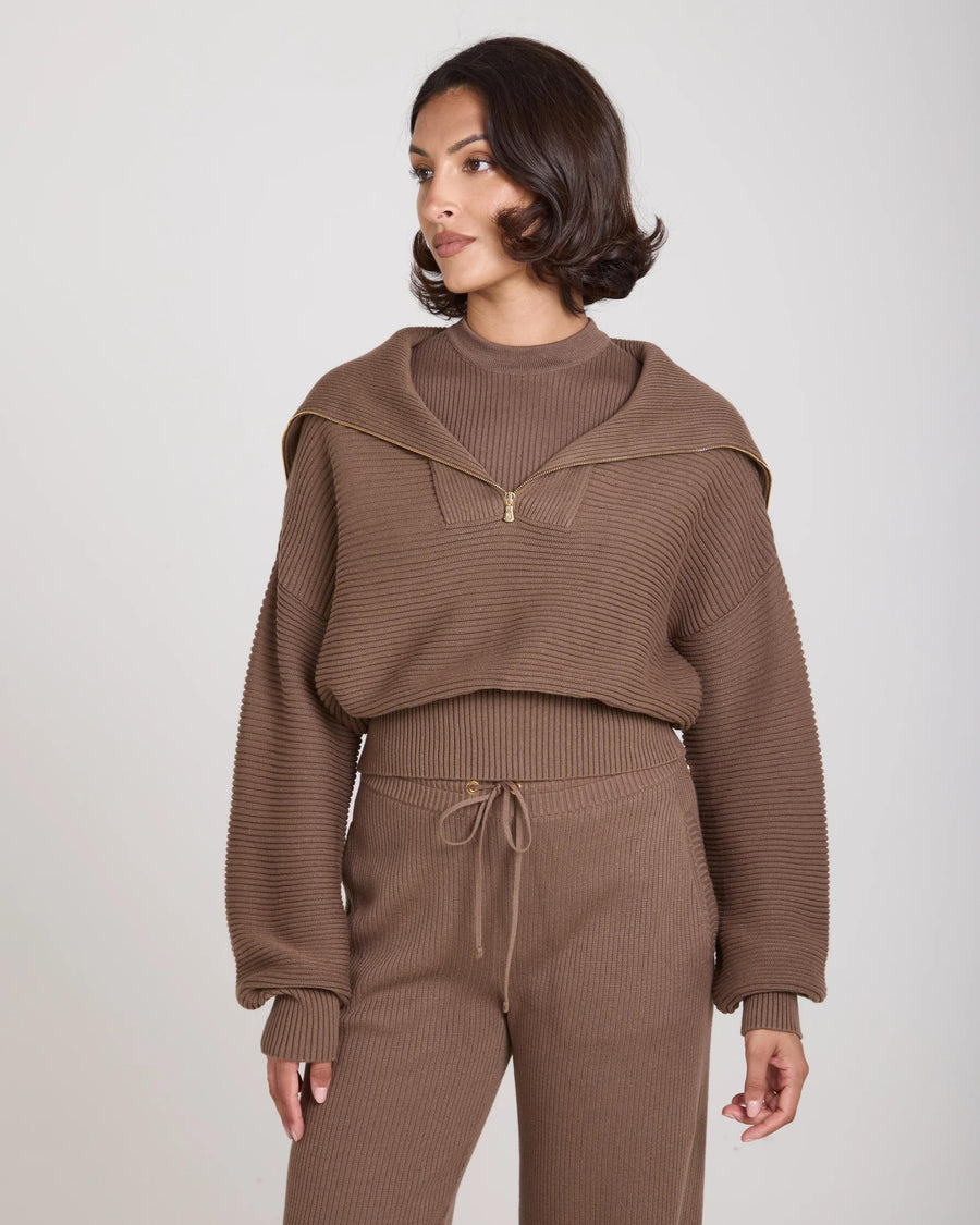 Model wearing taupe Sorella Ribbed Half Zip Jumper with relaxed silhouette and gold accents.