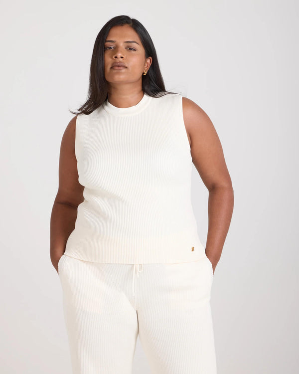 Sorella Ribbed Knit Vest in cream worn by a model, showcasing its sleeveless, slim fit and ribbed texture, crafted from cotton-cashmere.