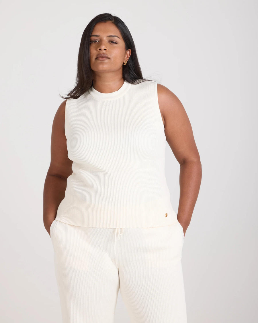 Sorella Ribbed Knit Vest in cream worn by a model, showcasing its sleeveless, slim fit and ribbed texture, crafted from cotton-cashmere.