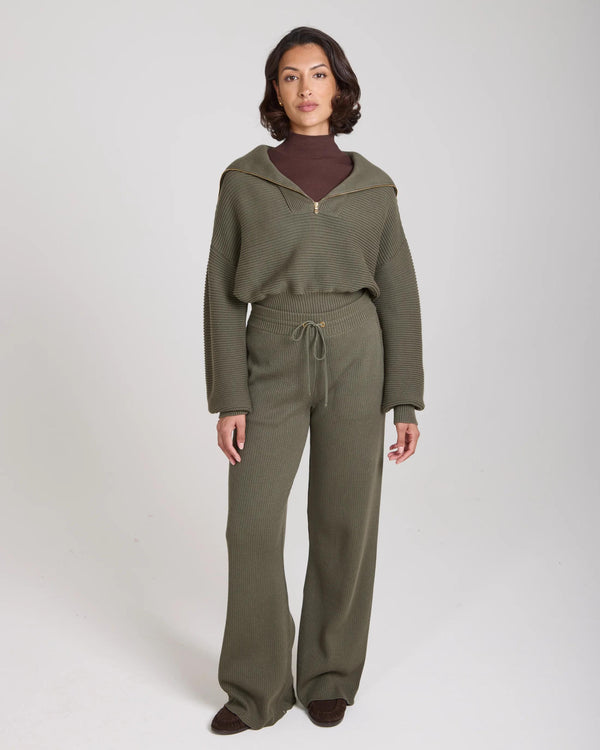 Model wearing Emello Sorella Ribbed Knit Wide Leg Trousers in Olive.