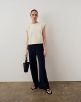 Model wearing Emello's Structured Layered Vest in cream, paired with wide-leg trousers.
