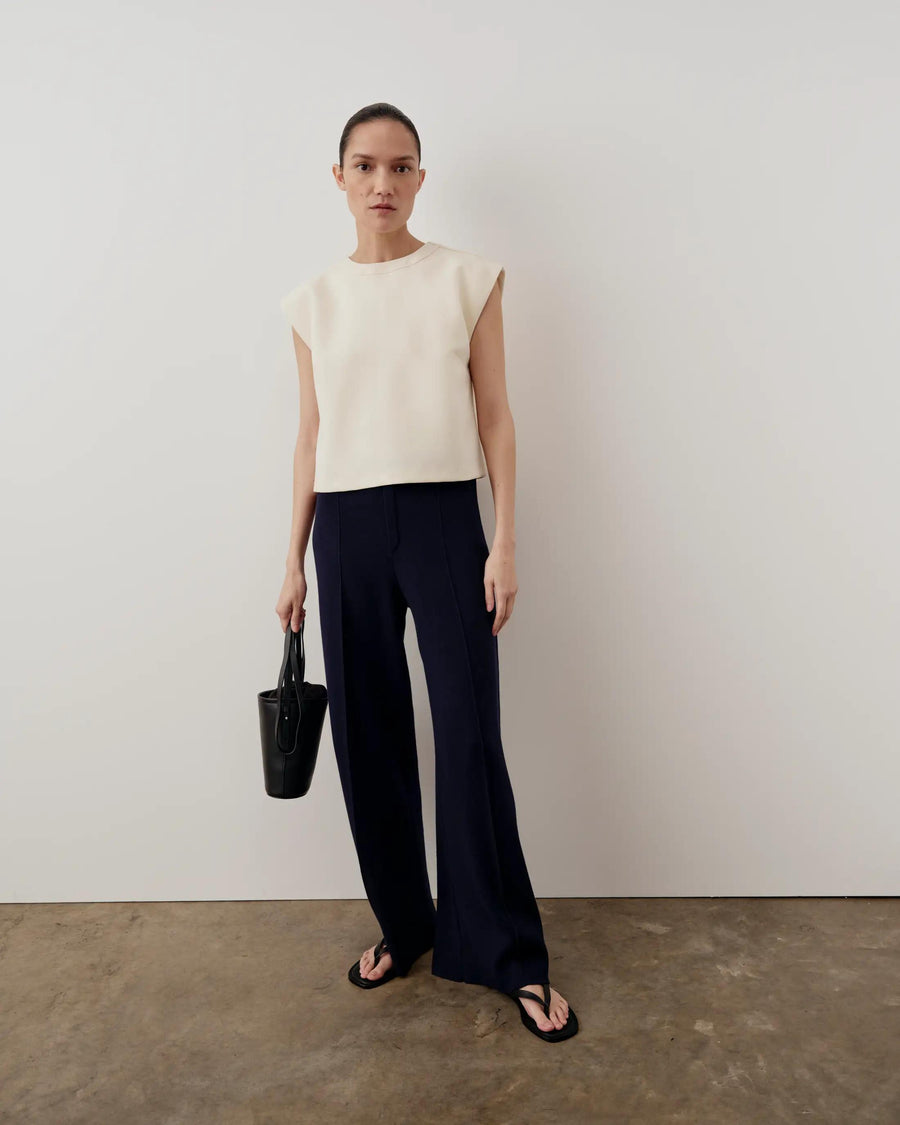 Model wearing Emello's Structured Layered Vest in cream, paired with wide-leg trousers.