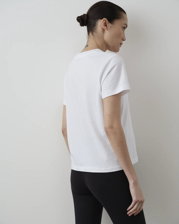 Back view of model wearing Emello's Supima Cotton Pocket Tee in white, displaying the clean lines and elegant simplicity of the design.
